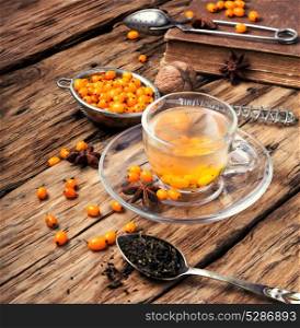 tea with sea-buckthorn. autumn sea-buckthorn tea on an old vintage wooden background
