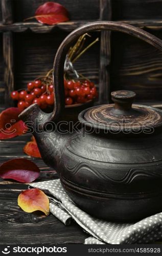 Tea with viburnum. Stylish teapot with tea from medicinal autumn berries tea with viburnum