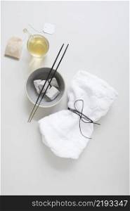 teabag oil pumice stone incense stick tied napkin white surface