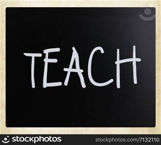 ""Teach" handwritten with white chalk on a blackboard"