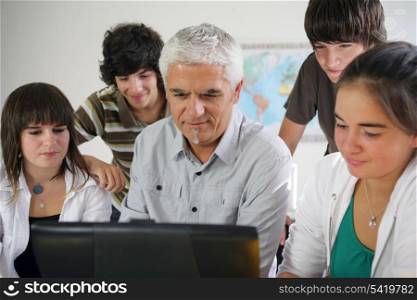Teacher and pupils gathered around computer