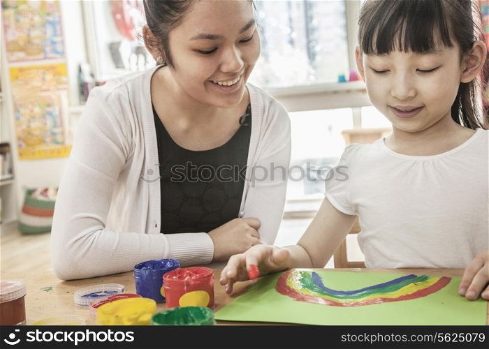 Teacher and student finger painting in art class