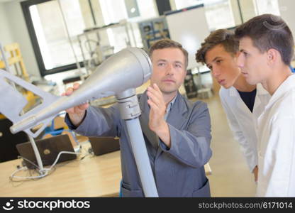 Teacher and students looking at an airplane shaped model