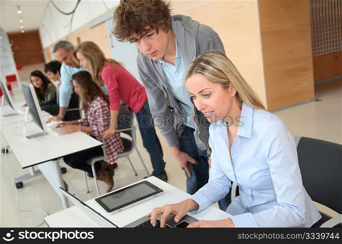 Teacher and teenage boy in front of laptop computer