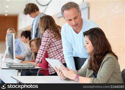 Teacher and teenage girl working on electronic tablet