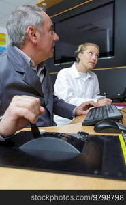 teacher and young professional worker demonstrating new technology