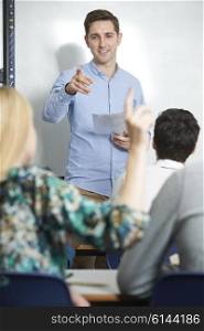 Teacher Answering Pupils Question In Classroom