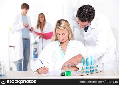 Teacher assisting pupils in science class