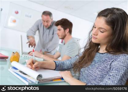 teacher at university with students taking notes