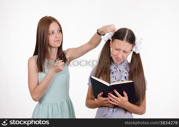 Teacher bangs his hand on the head and scolds student