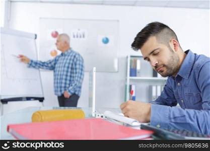 teacher drawing graph on office white board