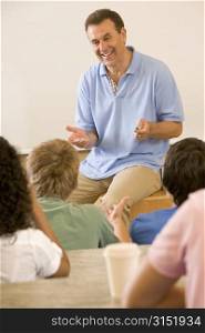 Teacher giving lecture to students in classroom (selective focus)