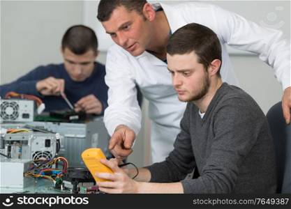 teacher guiding student on how to use multimeter