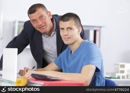 teacher helping college student with studies in library