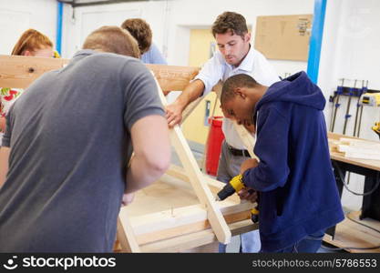 Teacher Helping College Students Studying Carpentry