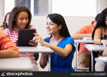 Teacher Helping Female High School Student In Classroom