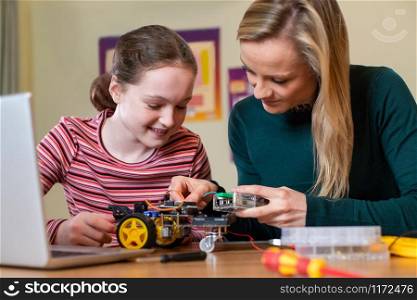 Teacher Helping Female Pupil To Build Robot Car In Science Lesson
