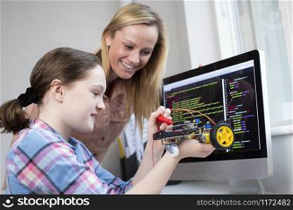 Teacher Helping Female Pupil To Build Robot Car In Science Lesson