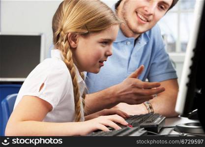 Teacher helping girl using computer in class