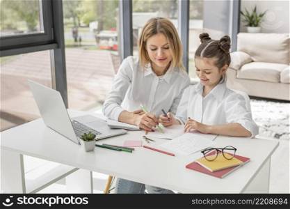 teacher helping her daughter study desk