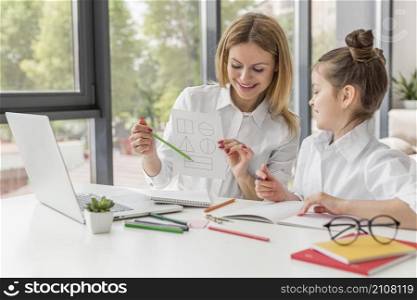 teacher helping her daughter study indoors
