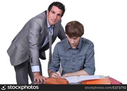 Teacher helping male teenager