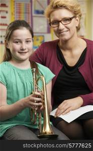 Teacher Helping Pupil To Play Trumpet In Music Lesson
