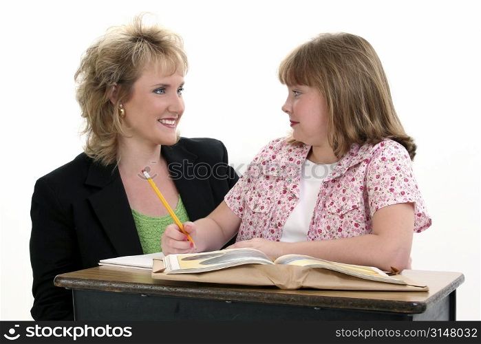 Teacher helping student at her desk.
