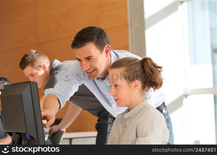 Teacher helping student girl with project