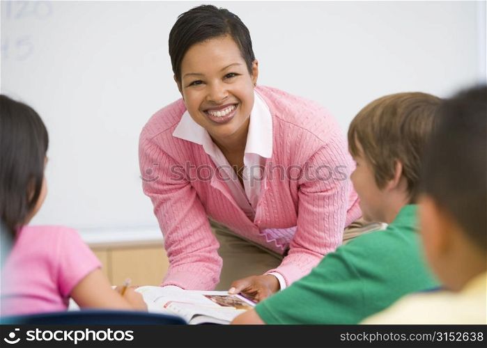 Teacher helping student in class (selective focus)