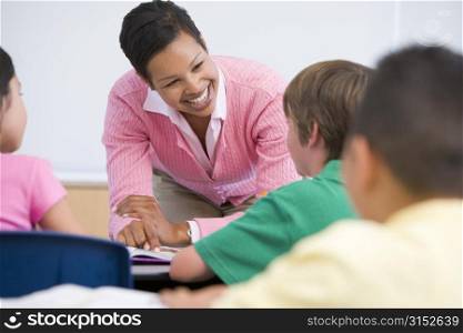 Teacher helping student in class (selective focus)