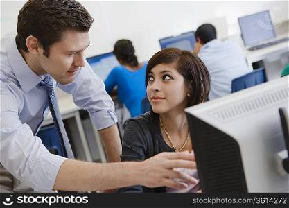 Teacher Helping Student in Computer Lab