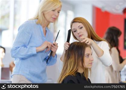 teacher helping student training to become a hairdresser