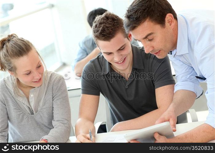 Teacher helping students with assignment