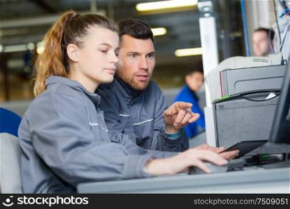 teacher helping students with laptop