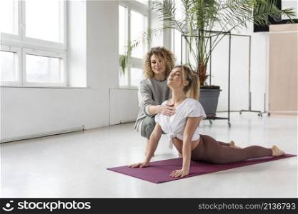 teacher helping woman with pose