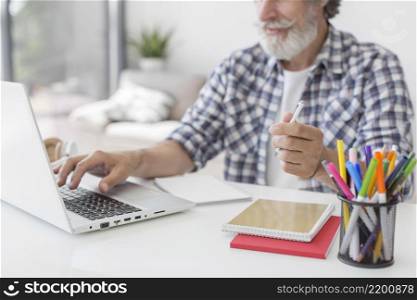 teacher holding pen using laptop