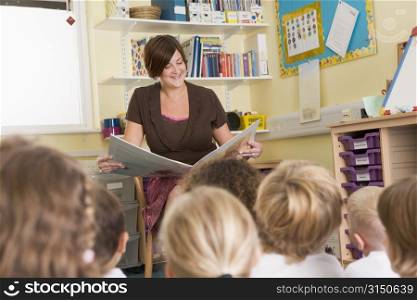 Teacher in class reading with students in foreground (selective focus)