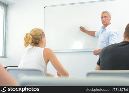 teacher in front of white board in classroom