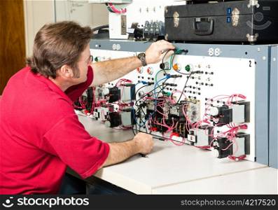 Teacher or adult student working on an industrial motor control panel trainer.