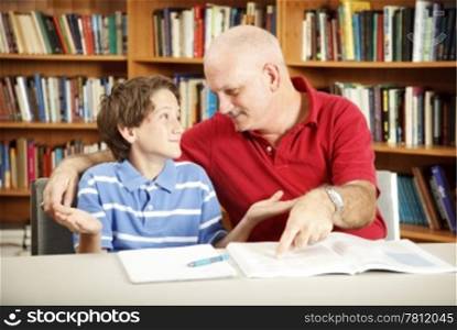 Teacher or parent working with a young boy who has learning disabilities.