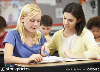 Teacher Reading With Female Pupil In Class