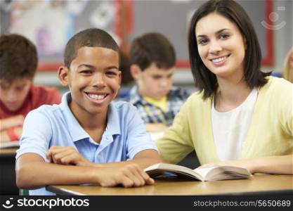 Teacher Reading With Male Pupil In Class