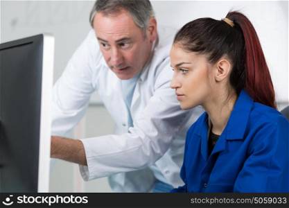 teacher showing student how to use a computer