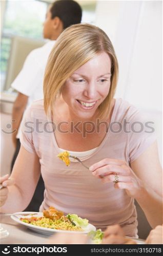 Teacher sitting at cafeteria table eating lunch