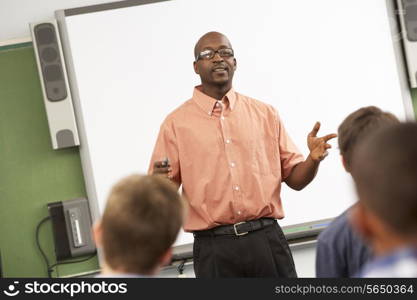 Teacher Talking To Class Standing In Front Of Whiteboard