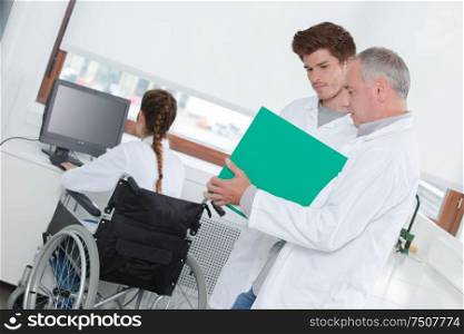 teacher talking to student female student in wheelchair in background
