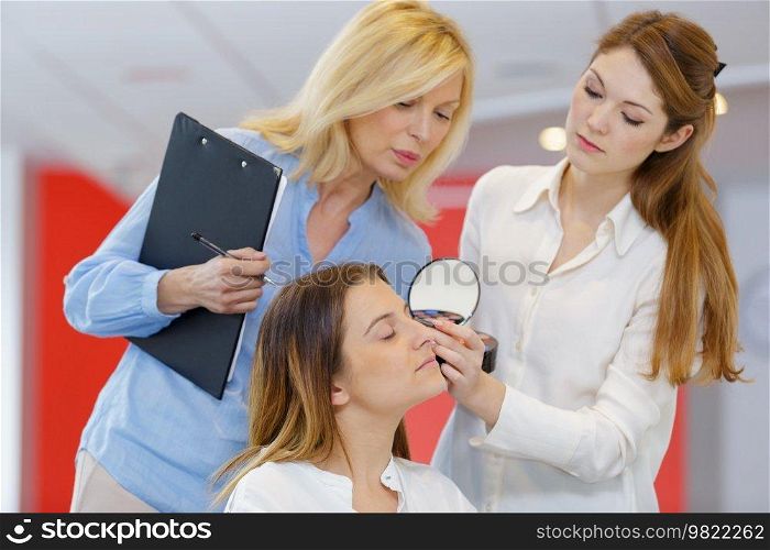 teacher training her student girl to become makeup artist