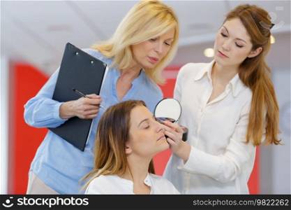 teacher training her student girl to become makeup artist
