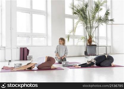 teacher watching women doing yoga